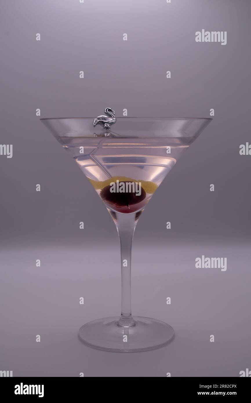 Reine Eleganz: Isolierter Martini mit Garnierung auf reinem weißem Hintergrund, garniert mit einer Kirsche Stockfoto