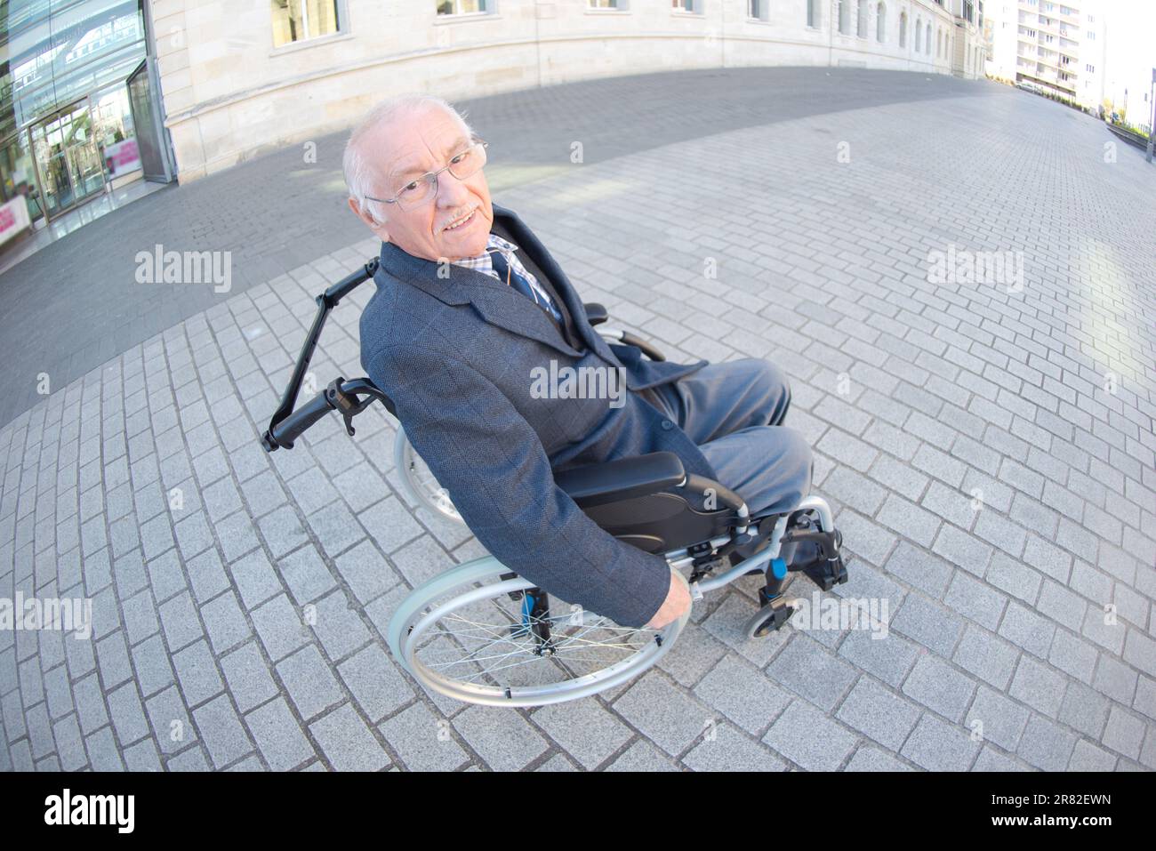 Fischaugensicht bei älteren Menschen im Rollstuhl im städtischen Umfeld Stockfoto