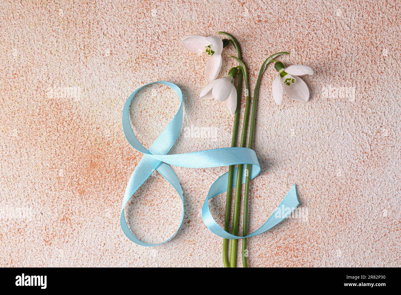 Schöne Schneetropfen und Nummer 8 aus Band auf farblich strukturiertem Hintergrund, flach liegend Stockfoto