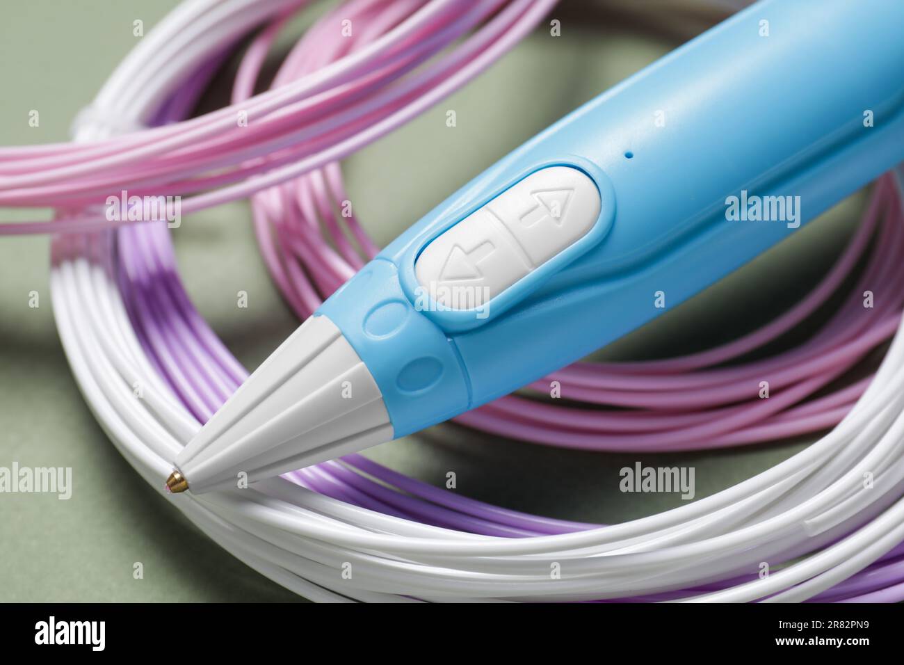 Eleganter 3D-Stift und farbenfrohe Kunststofffilamente auf Khaki-Hintergrund, Nahaufnahme Stockfoto
