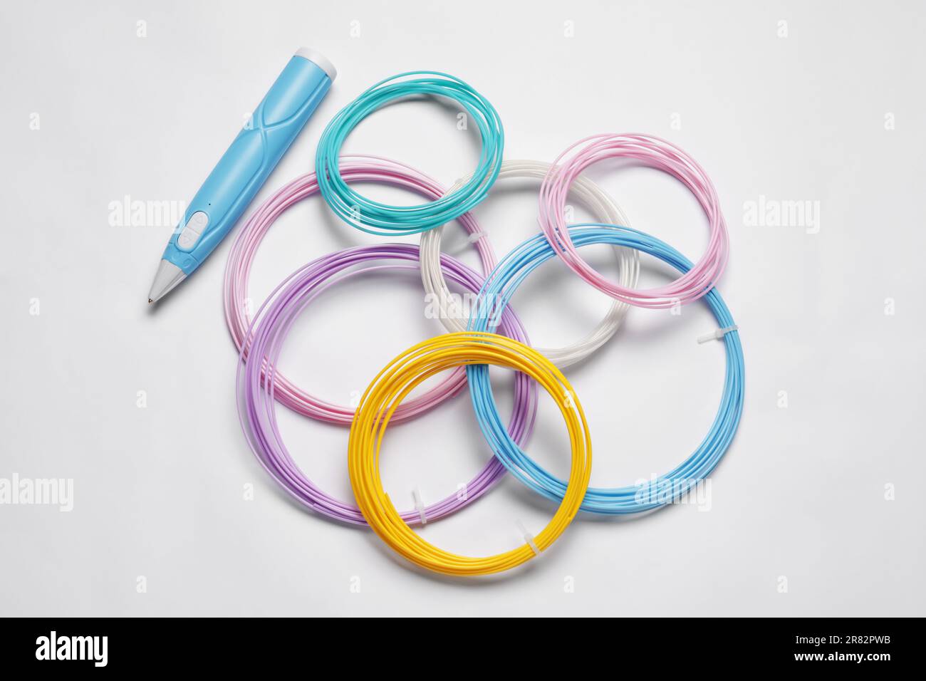 Eleganter 3D-Stift und farbenfrohe Kunststofffilamente auf weißem Hintergrund, flach liegend Stockfoto