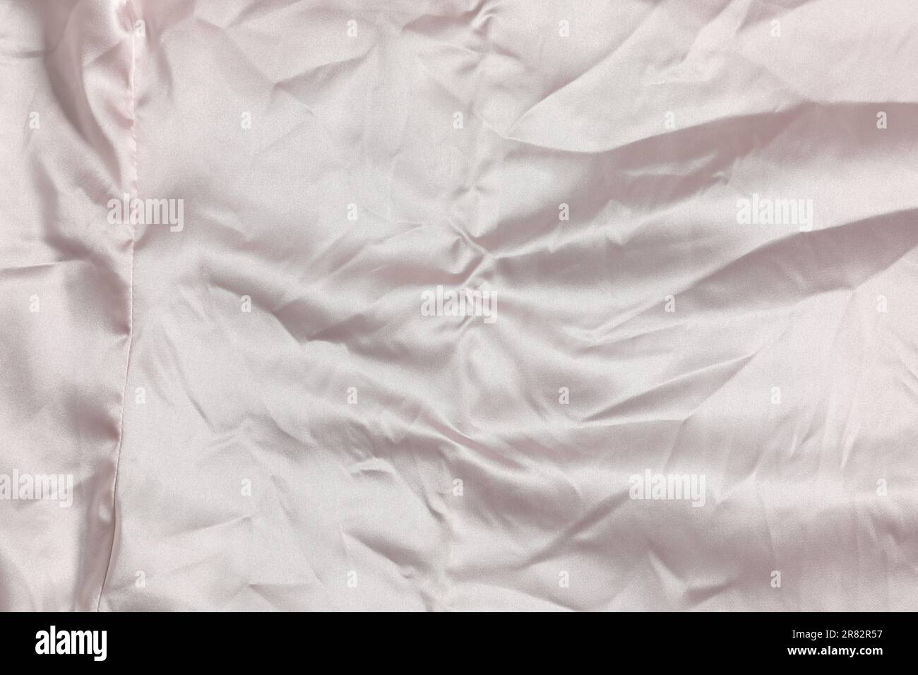 Zerknittertes hellrosa Material als Hintergrund, Draufsicht Stockfoto