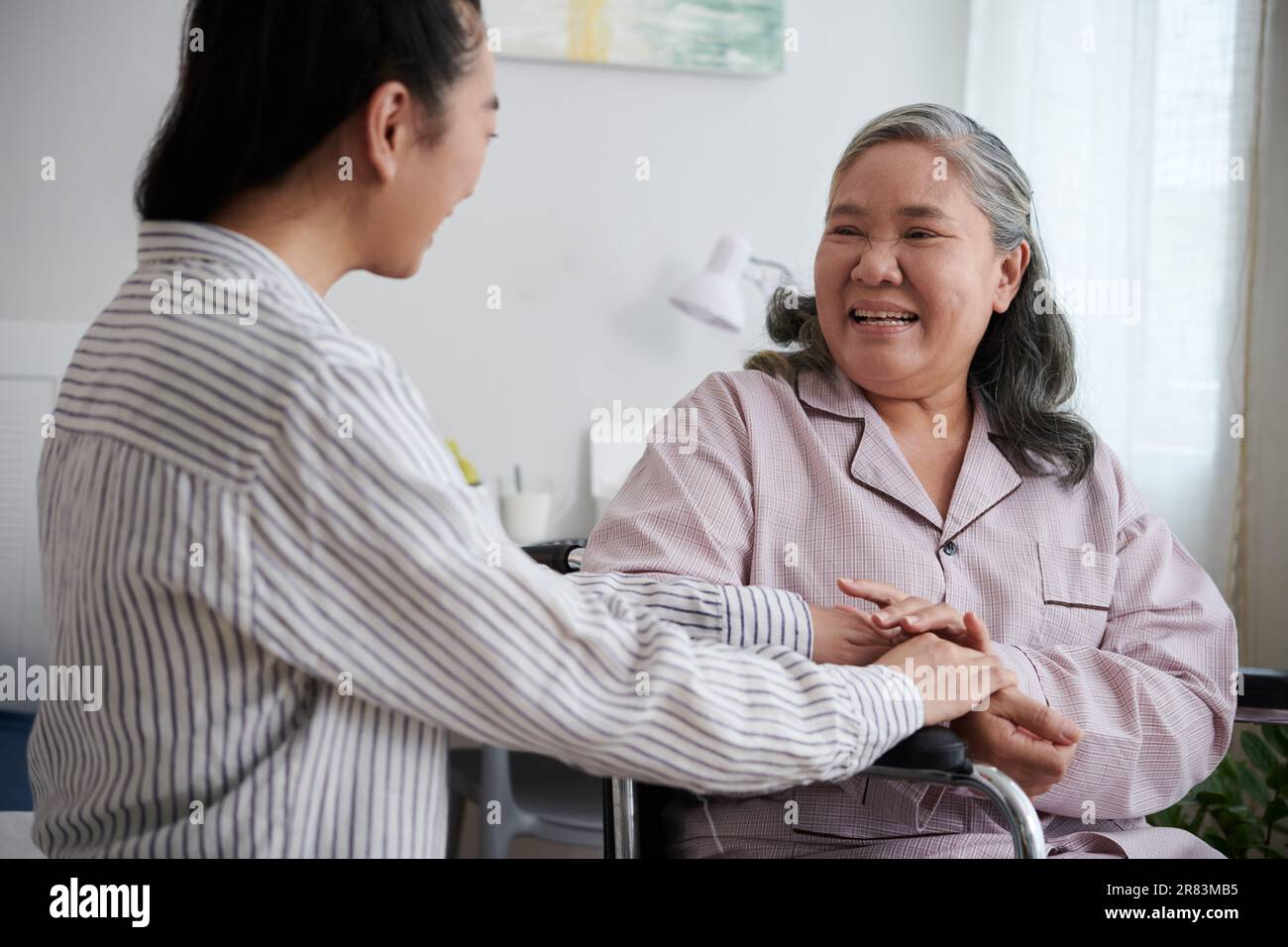 Ältere Frau freut sich, ihre Erwachsene Tochter im Pflegeheim zu sehen Stockfoto