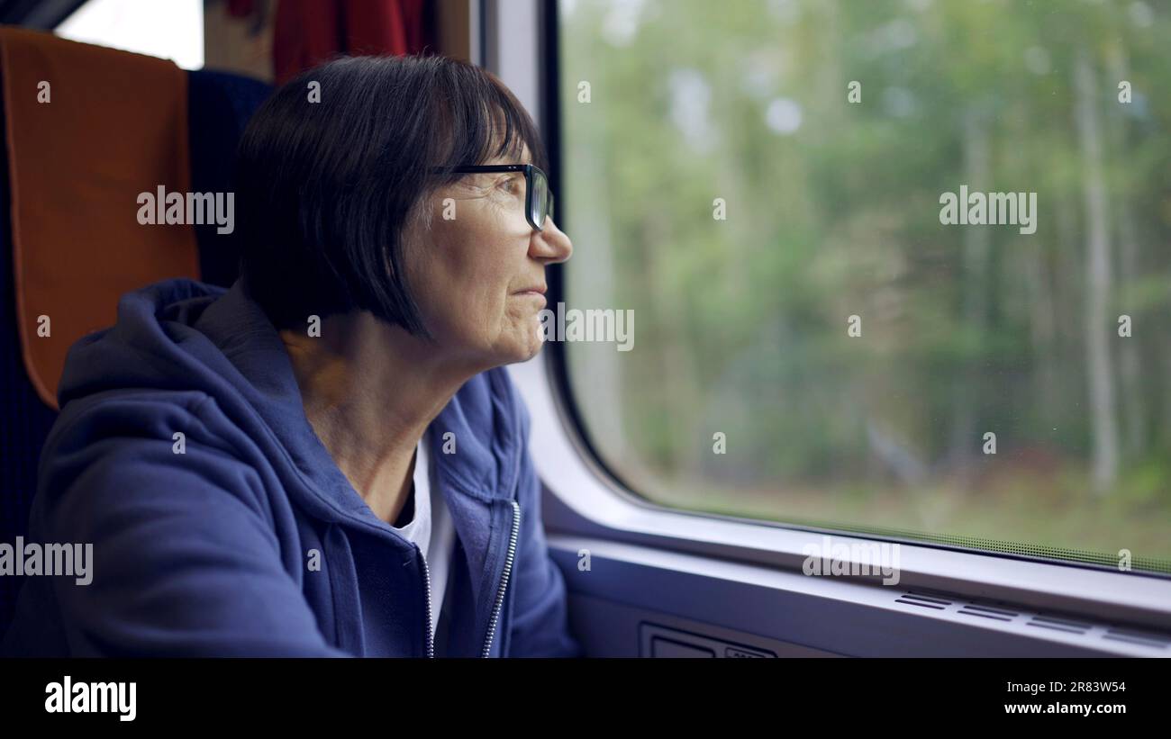 Warschau, Polen. 11. Juni 2023. Ältere Dame mit Brille reist im Zug und schaut aus dem Fenster (Kreditbild: © Andrey Nekrasov/ZUMA Press Wire), NUR REDAKTIONELLE VERWENDUNG! Nicht für den kommerziellen GEBRAUCH! Stockfoto