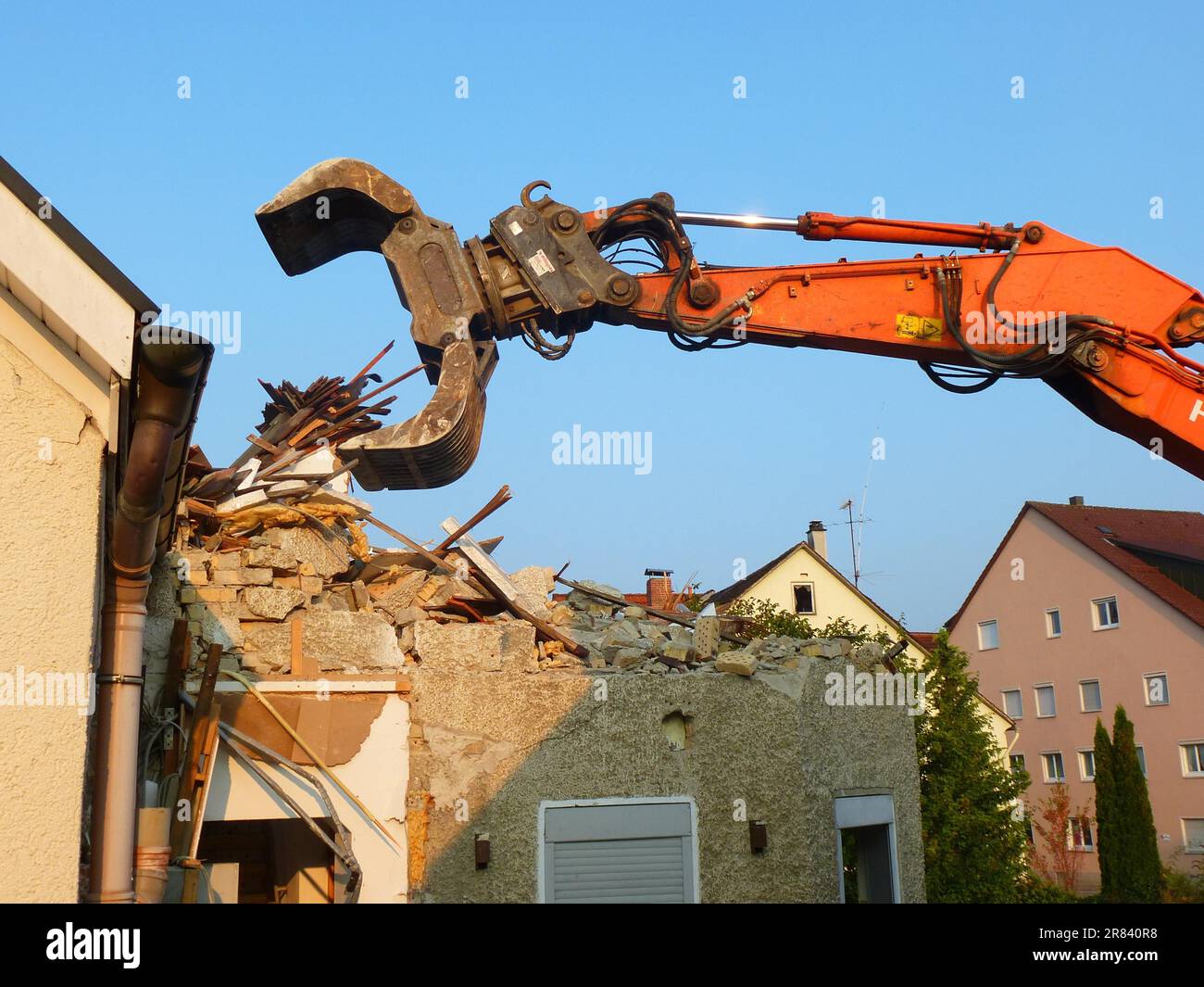 Ein altes Haus wird mit einem Bagger in einem städtischen Umbaugebiet abgerissen. Das Foto wurde im Weingarten (Württemberg) aufgenommen. In einem urbanisierten Stockfoto