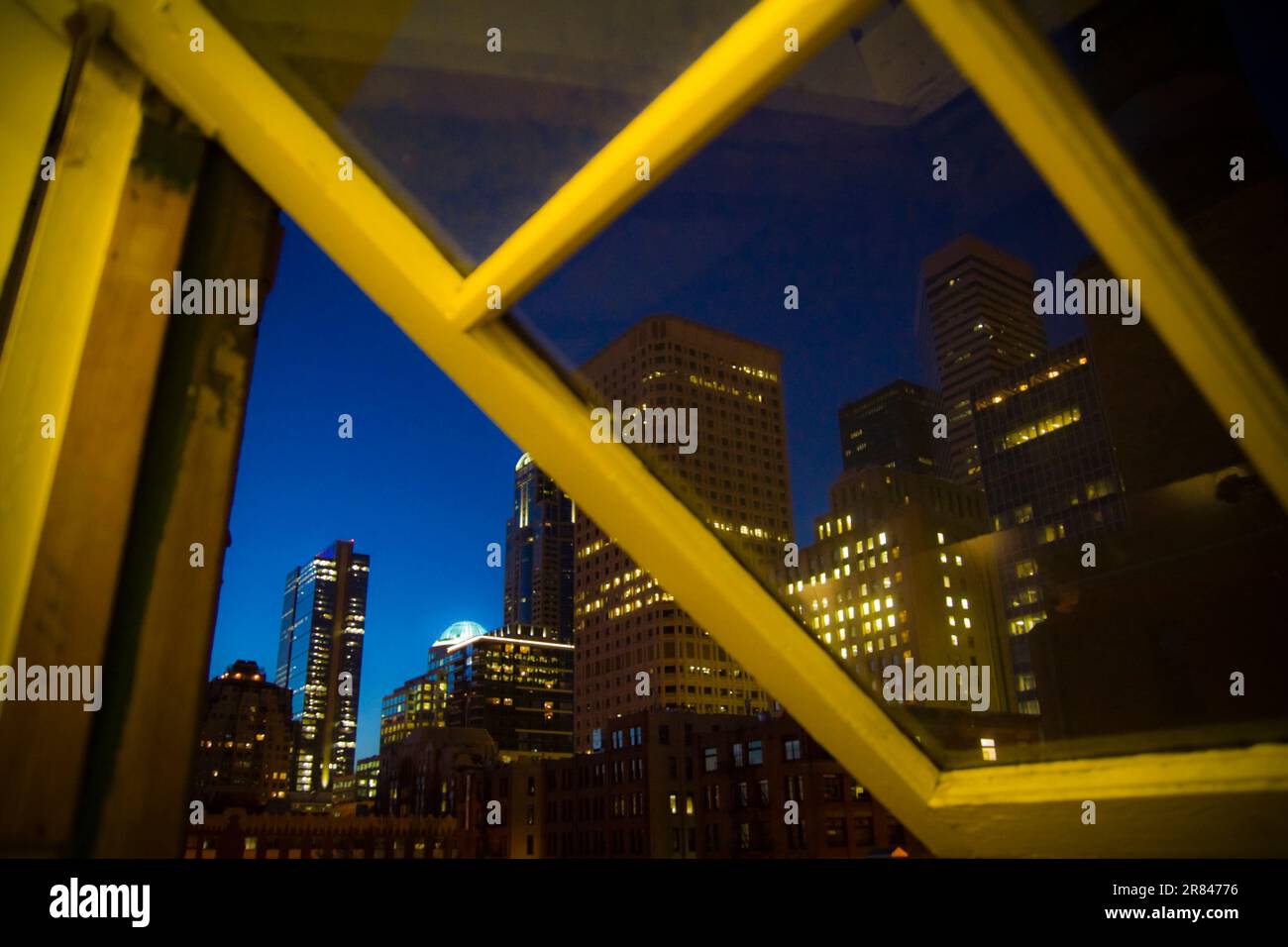 Wolkenkratzer im Zentrum von Seattle, Washington, in der Abenddämmerung, durch das Fenster eines Loft im Pioneer Square District zu sehen. Stockfoto