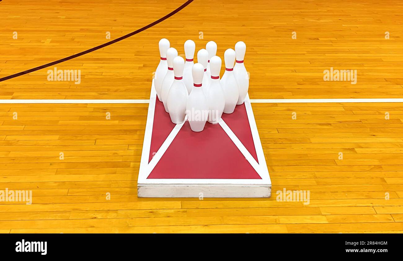 Bowling-Nadeln auf einem Maisloch-Spielbrett in einem Fitnessstudio für Spaß im Gymnastikunterricht. Stockfoto