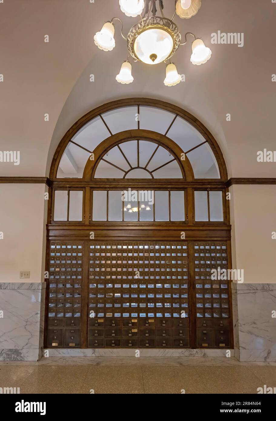 Ein Fenster, eine Leuchte und eine Reihe alter Briefkästen in Havre, Montana, USA Stockfoto