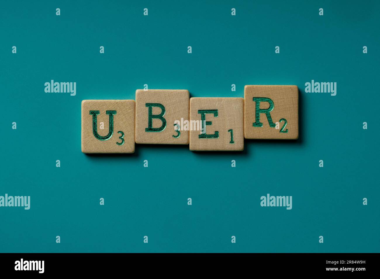 Die hölzernen Buchstaben, die das Wort Uber auf blauem Hintergrund buchstabieren Stockfoto