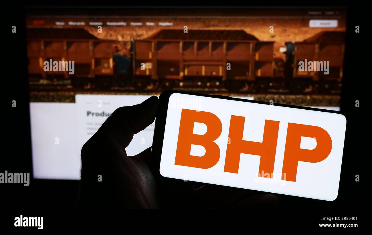Person, die ein Smartphone mit dem Logo des australischen Bergbauunternehmens BHP Group Limited auf dem Bildschirm vor der Website hält. Konzentrieren Sie sich auf das Display des Telefons. Stockfoto