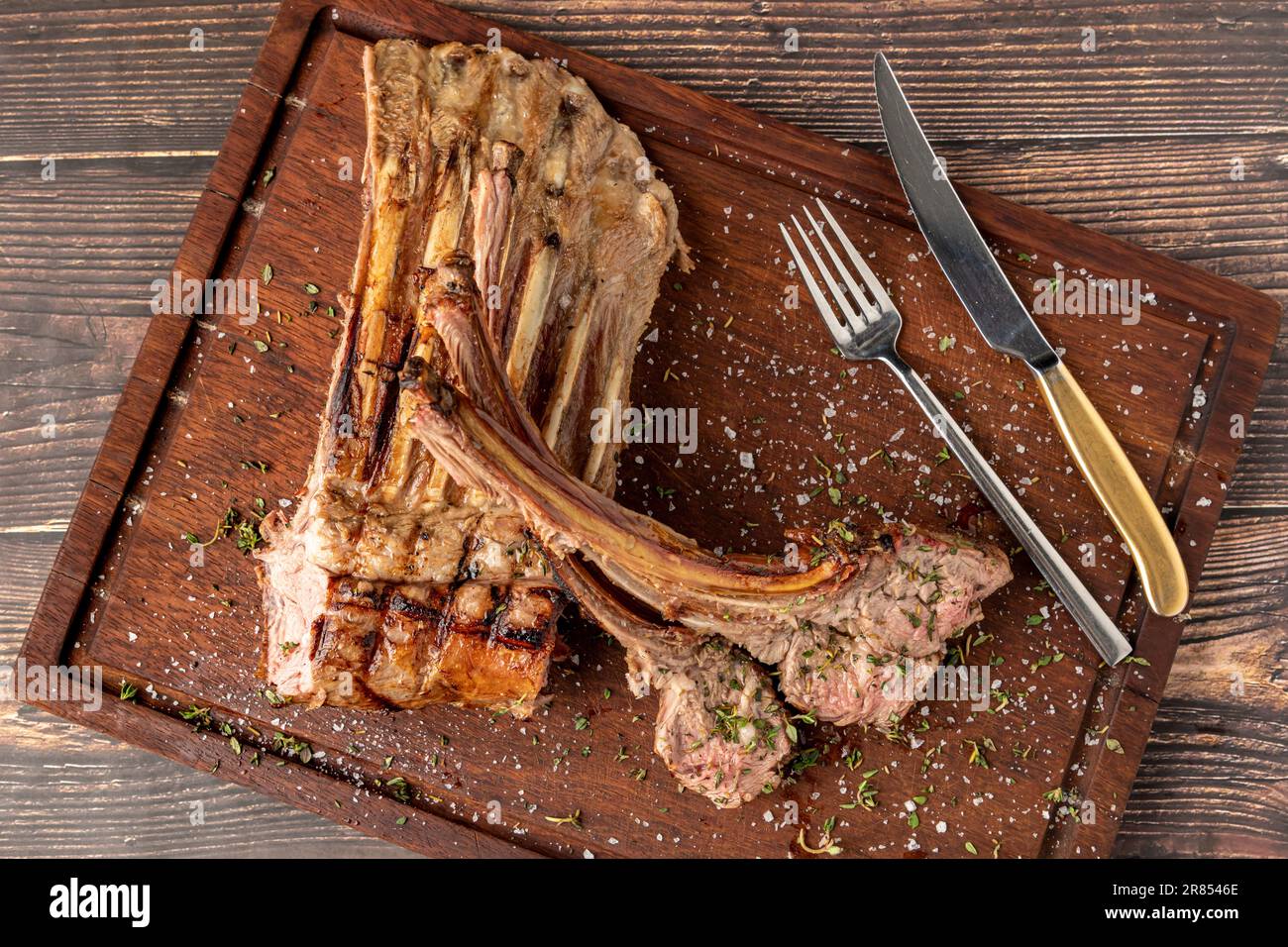 Gegrillte Lammkoteletts auf einem hölzernen Servierteller Stockfoto