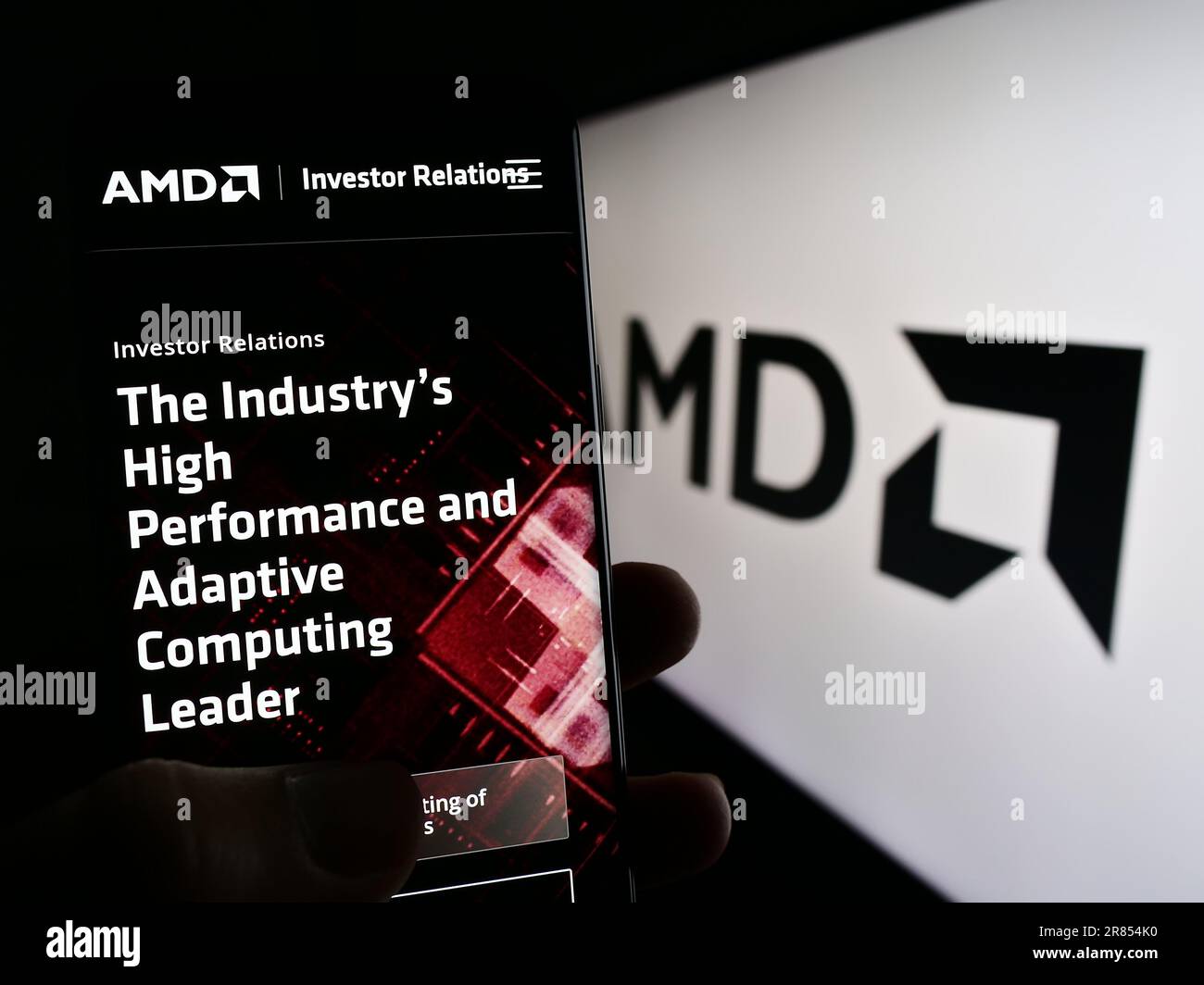 Person, die ein Mobiltelefon mit der Webseite des US-Unternehmens Advanced Micro Devices Inc. Besitzt (AMD) auf dem Bildschirm mit Logo. Konzentrieren Sie sich auf die Mitte des Telefondisplays. Stockfoto