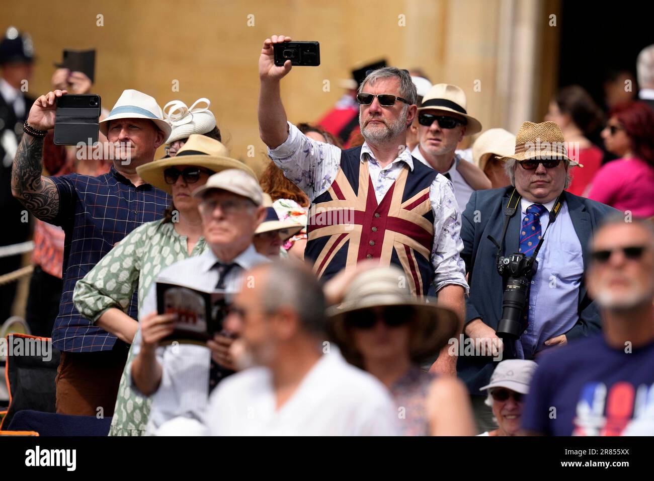 Besucher halten ihre Kameras bereit für die Ankunft der Gäste in der St. George's Chapel, die an der jährlichen Orden des Garter Service in Windsor Castle, Berkshire teilnehmen. Foto: Montag, 19. Juni 2023. Stockfoto
