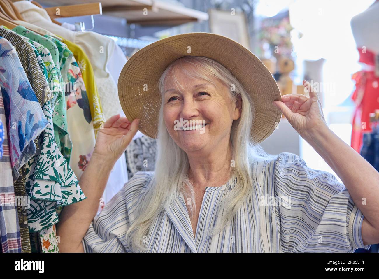 Seniorin, Die Gebrauchte Nachhaltige Kleidung Aus Einem Second Hand Charity Shop Oder Thrift Store Kauft Und Einen Hut Anprobiert Stockfoto