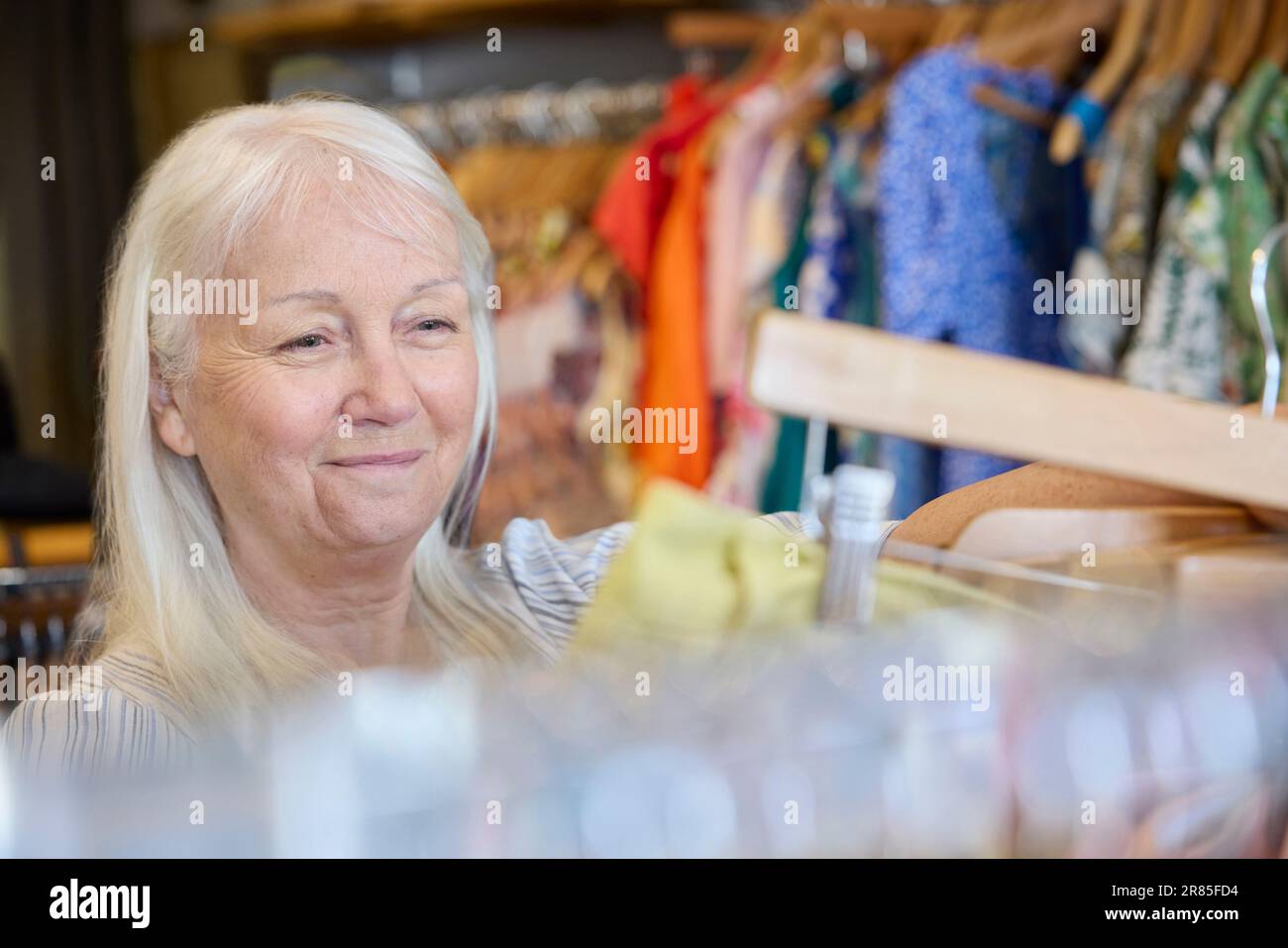 Ältere Frau, Die Gebrauchte Nachhaltige Kleidung Aus Einem Second Hand Charity Shop Oder Thrift Store Kauft Stockfoto
