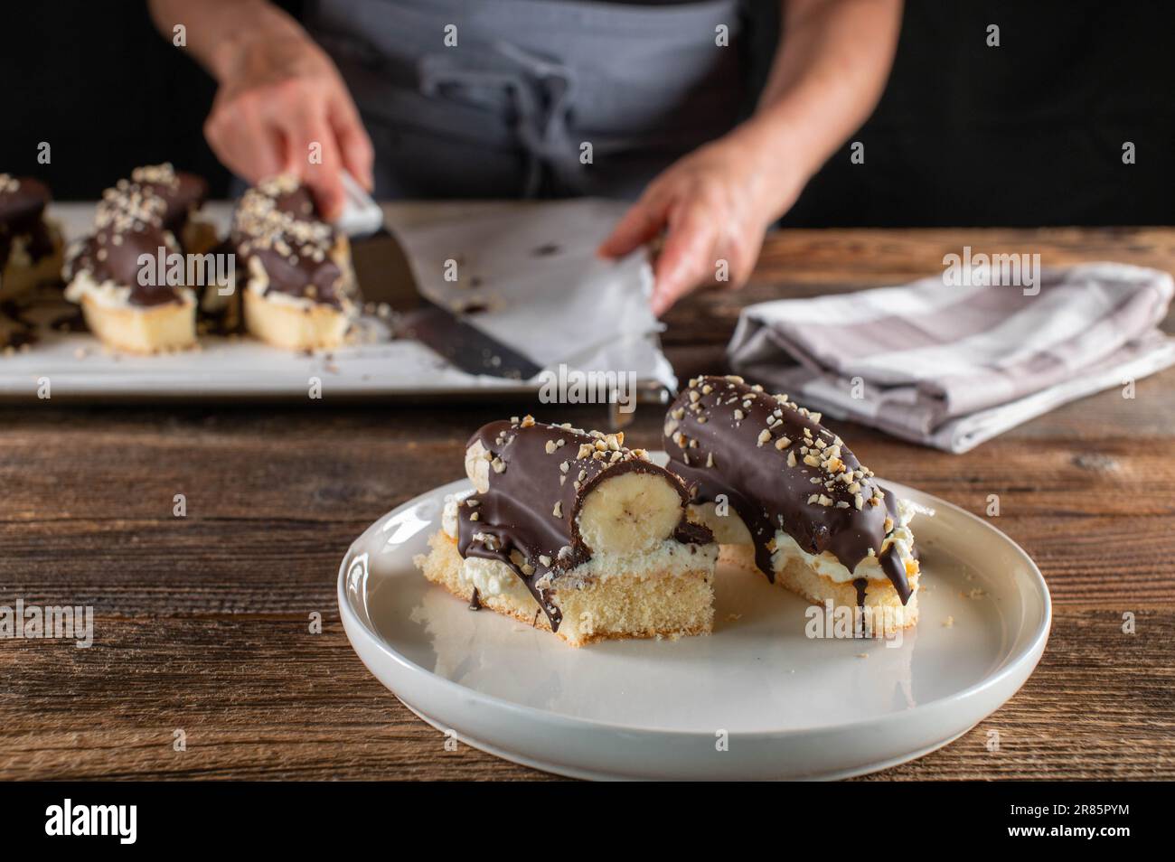 Schokoladen-Bananen-Dessert mit ganzen überdachten Bananen, Schlagsahne und Biskuitbasis Stockfoto