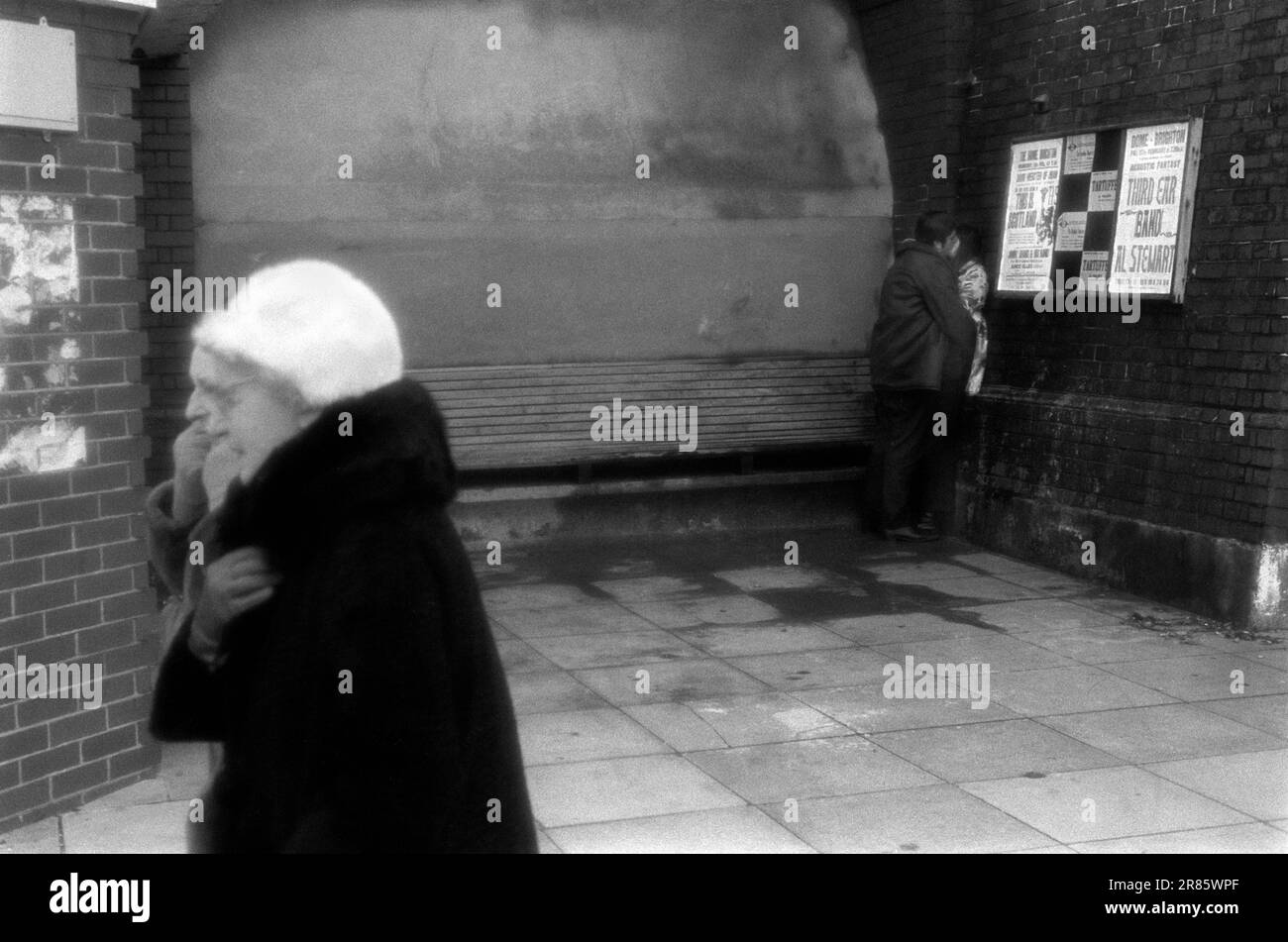 Brighton kaltes Winterwetter, zwei ältere Frauen gehen zusammen spazieren und ein junges Paar küsst sich in einer Ecke aus dem Wind. Brighton, Sussex, England, ca. 1969. 1960S GB HOMER SYKES Stockfoto