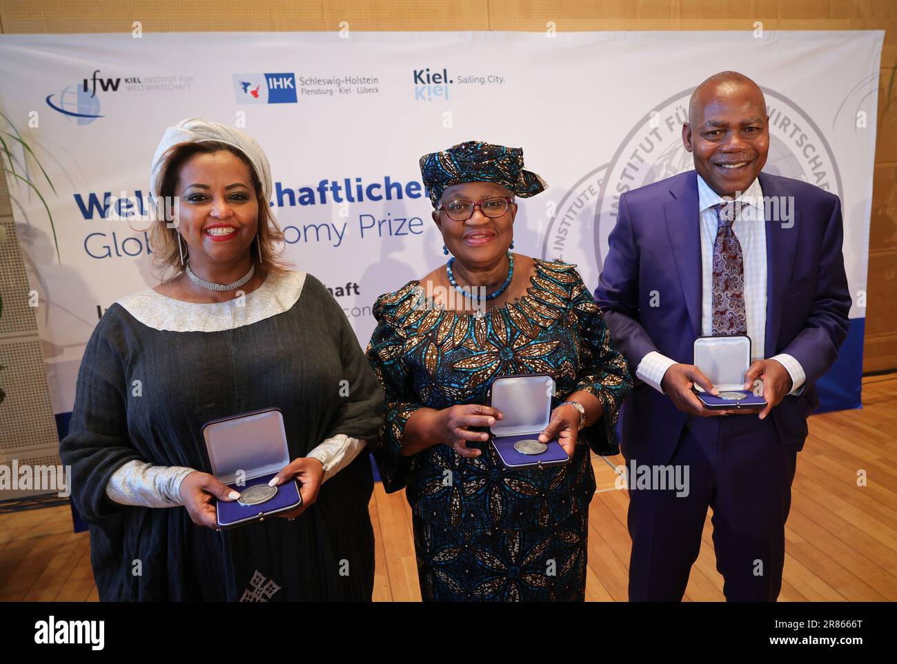 19. Juni 2023, Schleswig-Holstein, Kiel: Preisträger Eleni Gabre-Madhin (l), Büro der Vereinten Nationen für Afrika, und Ngozi Okonjo-Iweala, Generaldirektor der Welthandelsorganisation, und Preisträger Leonard Wantchekon (r), Universität Princeton, halten nach der Verleihung des Weltwirtschaftspreises 2023 im Landeshaus zusammen mit ihren Medaillen. Das Kieler Institut für Weltwirtschaft, die Landeshauptstadt und die Industrie- und Handelskammer Schleswig-Holstein verleihen den nicht ausgegebenen Preis seit 2005 jährlich. Es geht an die Vordenker einer kosmopolitischen, freien Markt- und sozialen Gesellschaft. Stockfoto