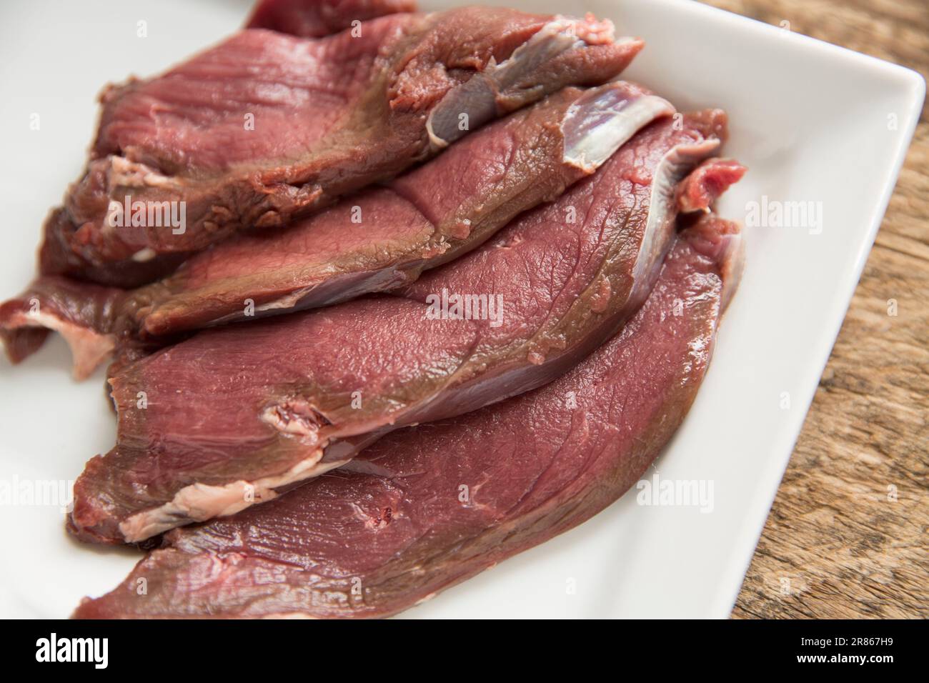 Rohe Venissenscheiben von einem wilden Reh, Capreolus capreolus, die in einer schwarzen Bohnensauce hausgekocht werden. England GB Stockfoto