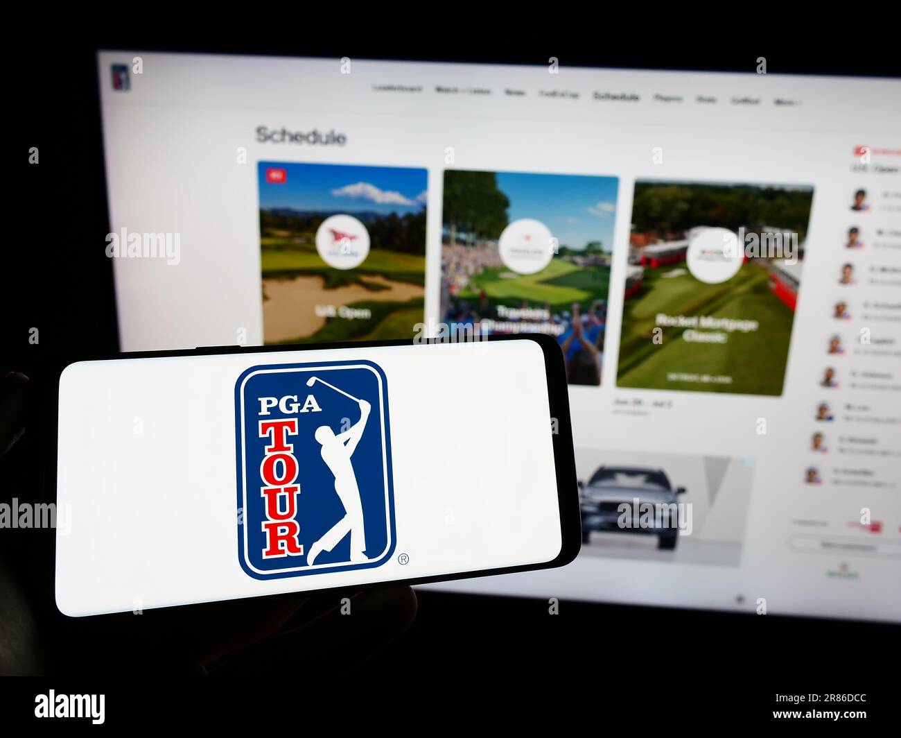 Person mit Handy mit Logo der US-Golforganisation PGA Tour auf dem Bildschirm vor der Webseite. Konzentrieren Sie sich auf das Display des Telefons. Stockfoto