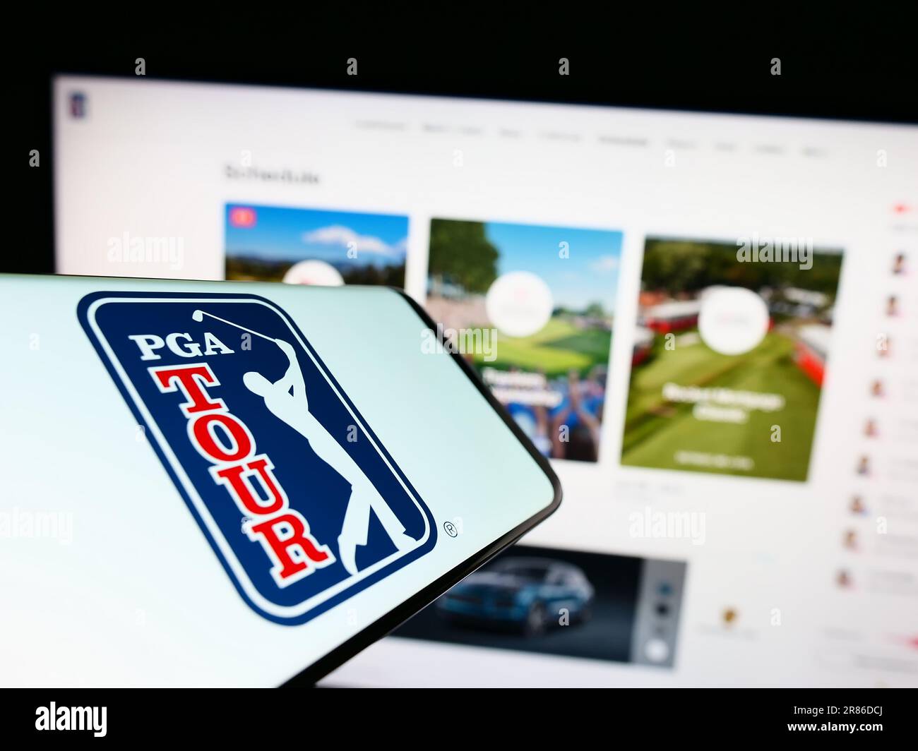 Mobiltelefon mit Logo der amerikanischen Golforganisation PGA Tour auf dem Bildschirm vor der Website. Fokus auf die Mitte rechts des Telefondisplays. Stockfoto