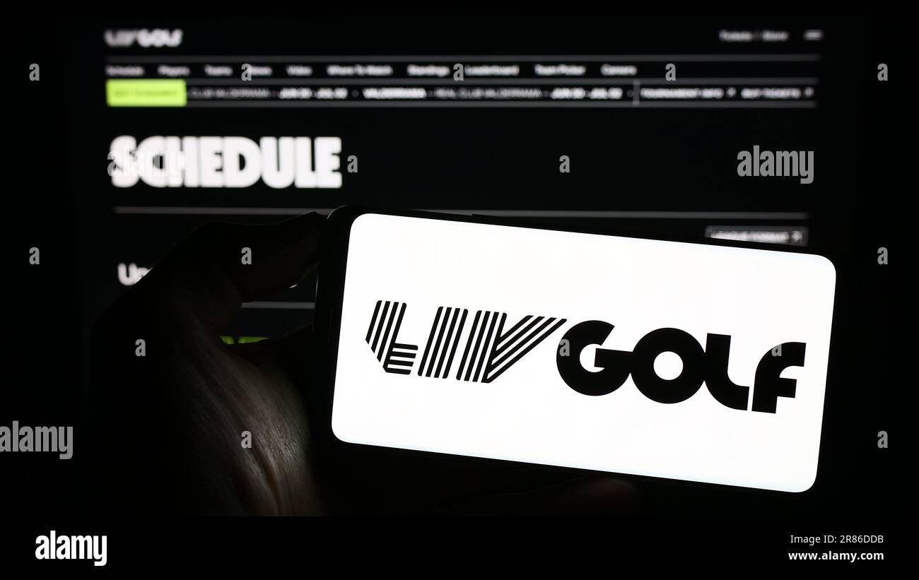 Person, die ein Mobiltelefon mit dem Logo der Sportorganisation LIV Golf auf dem Bildschirm vor der Webseite hält. Konzentrieren Sie sich auf das Display des Telefons. Stockfoto