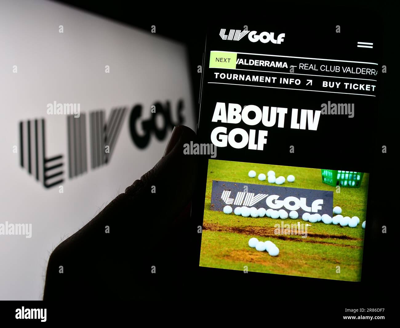 Person, die ein Smartphone mit der Website der Sportorganisation LIV Golf auf dem Bildschirm vor dem Logo hält. Konzentrieren Sie sich auf die Mitte des Telefondisplays. Stockfoto