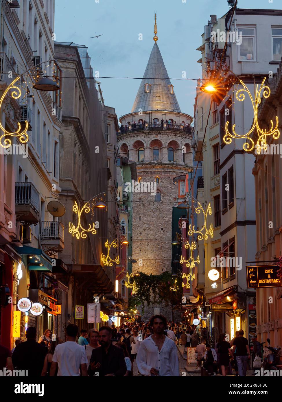 Touristen auf der Straße unter dem Galatenturm am Abend und Touristen genießen die Aussicht vom Turm, Istanbul, Türkei Stockfoto