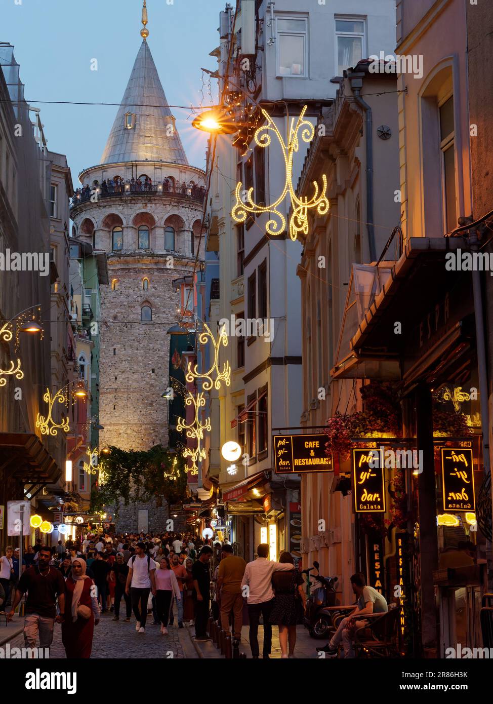 Touristen auf der Straße unter dem Galatenturm am Abend und Touristen genießen die Aussicht vom Turm, Istanbul, Türkei Stockfoto