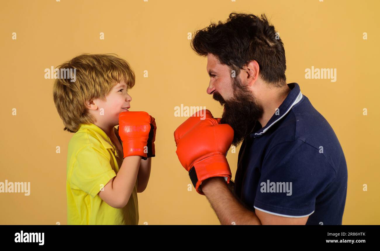 Kleiner Boxer mit Trainer beim Boxtraining. Kind mit Boxtrainer bereit zum Sparring. Junge und Trainer in Boxhandschuhen. Kind und Trainer rein Stockfoto