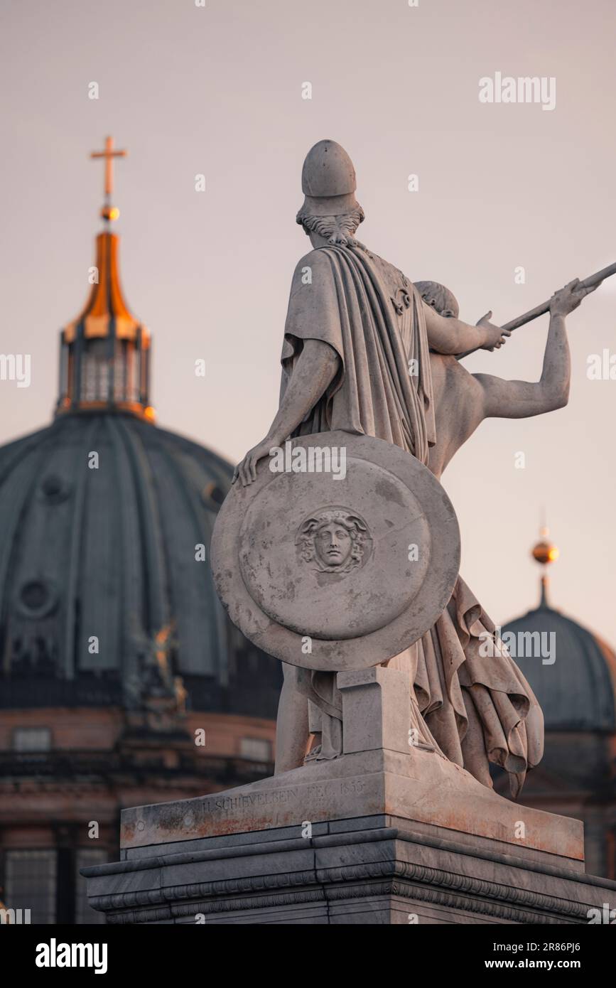 Eine majestätische Bronzestatue eines Ritters, die ein Schwert und Schild trägt, steht auf einem hohen Gebäude Stockfoto