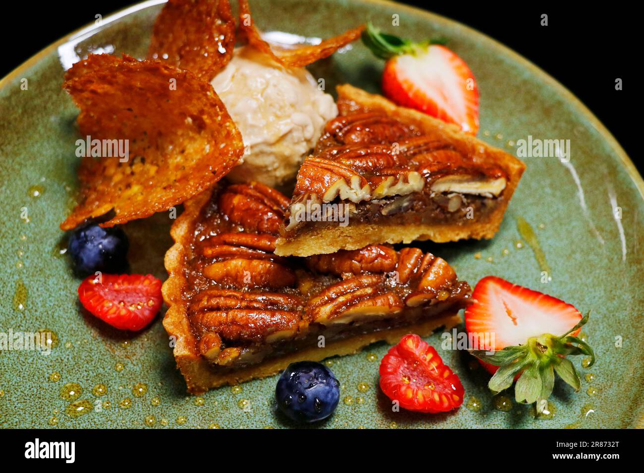 Pekannusskuchen mit Vanilleeis und frischen Beeren Stockfoto
