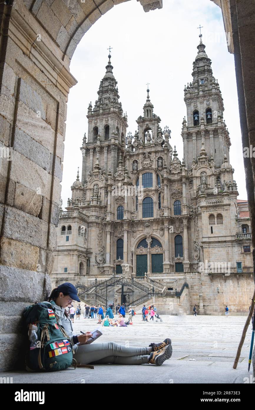 Junge Pilgerin, die ein Buch in Santiago de Compostela, La Coruna, Galicien, Spanien liest. Stockfoto