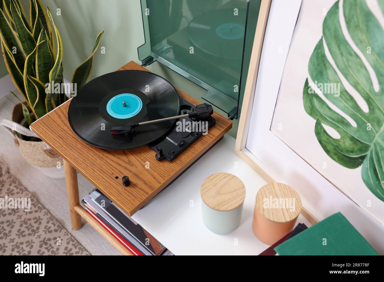 Stilvoller Plattenspieler mit Schallplatte auf dem Konsolentisch in gemütlichem Zimmer, Blick über die Kulisse Stockfoto
