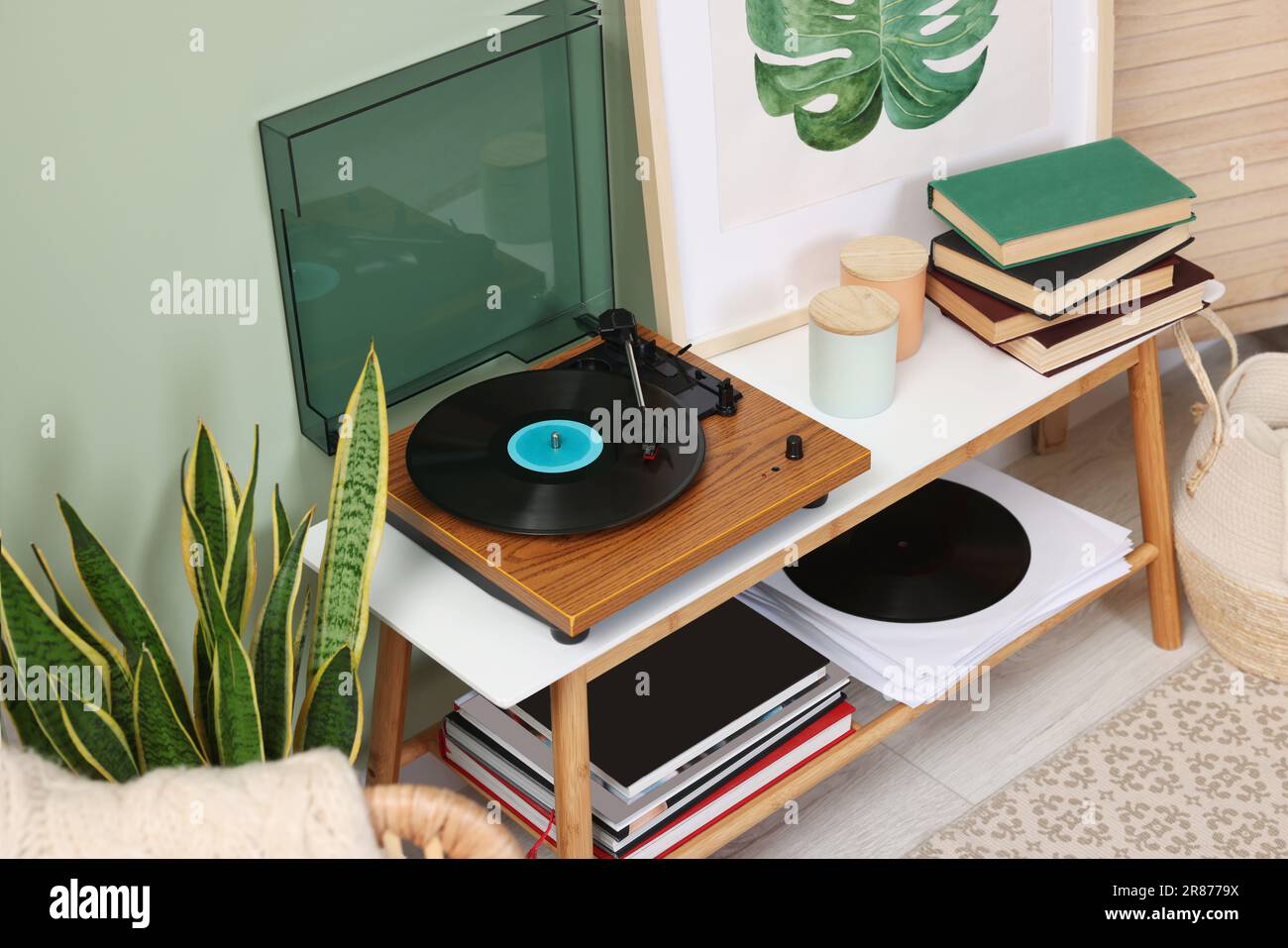 Eleganter Plattenspieler mit Konsolentisch aus Vinyl-Schallplatten im Zimmer Stockfoto