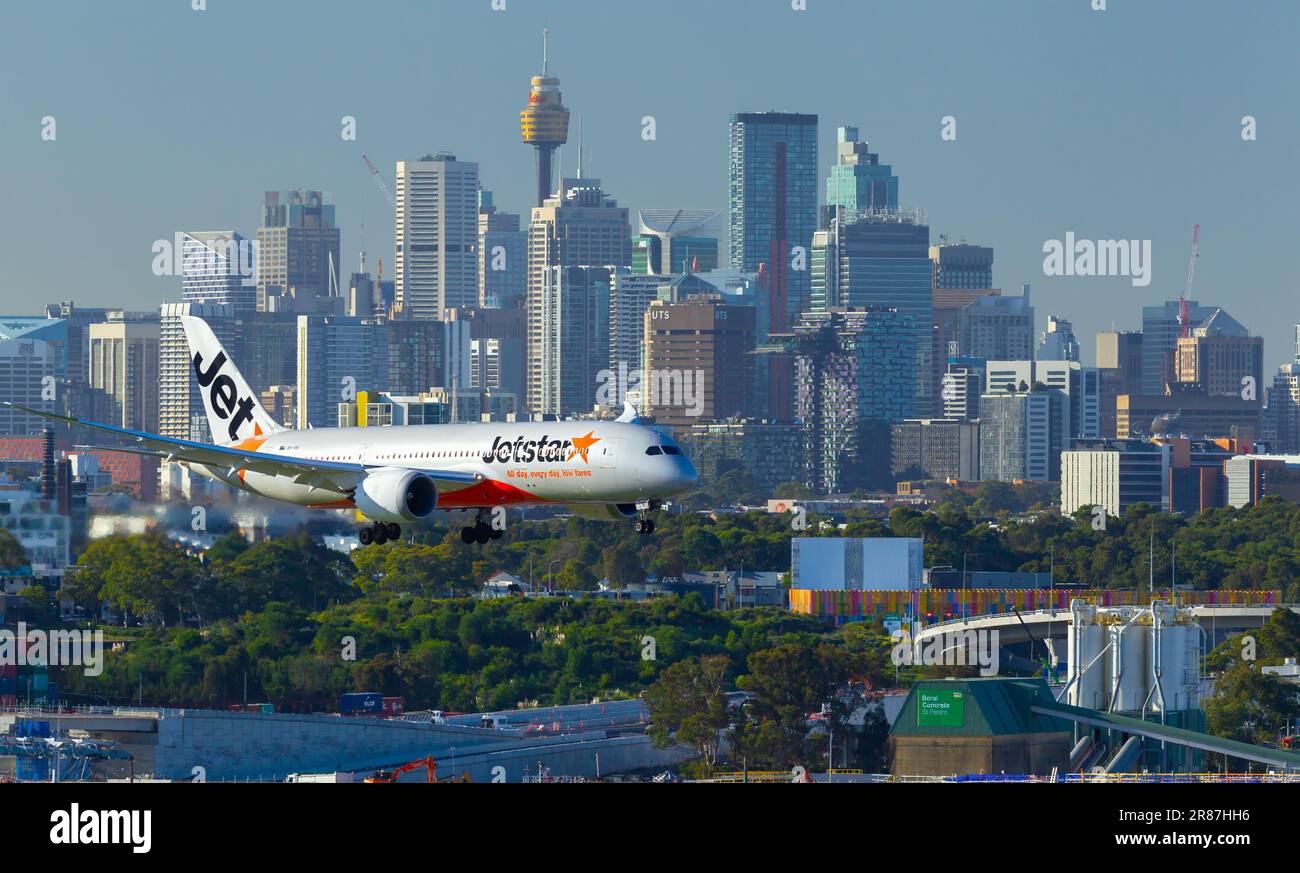 Ein Jetstar-Flugzeug mit dem Kennzeichen VH-VKI, das am Sydney (Kingsford Smith) Airport in Sydney, Australien, landet, mit der Skyline von Sydney im Hintergrund Stockfoto