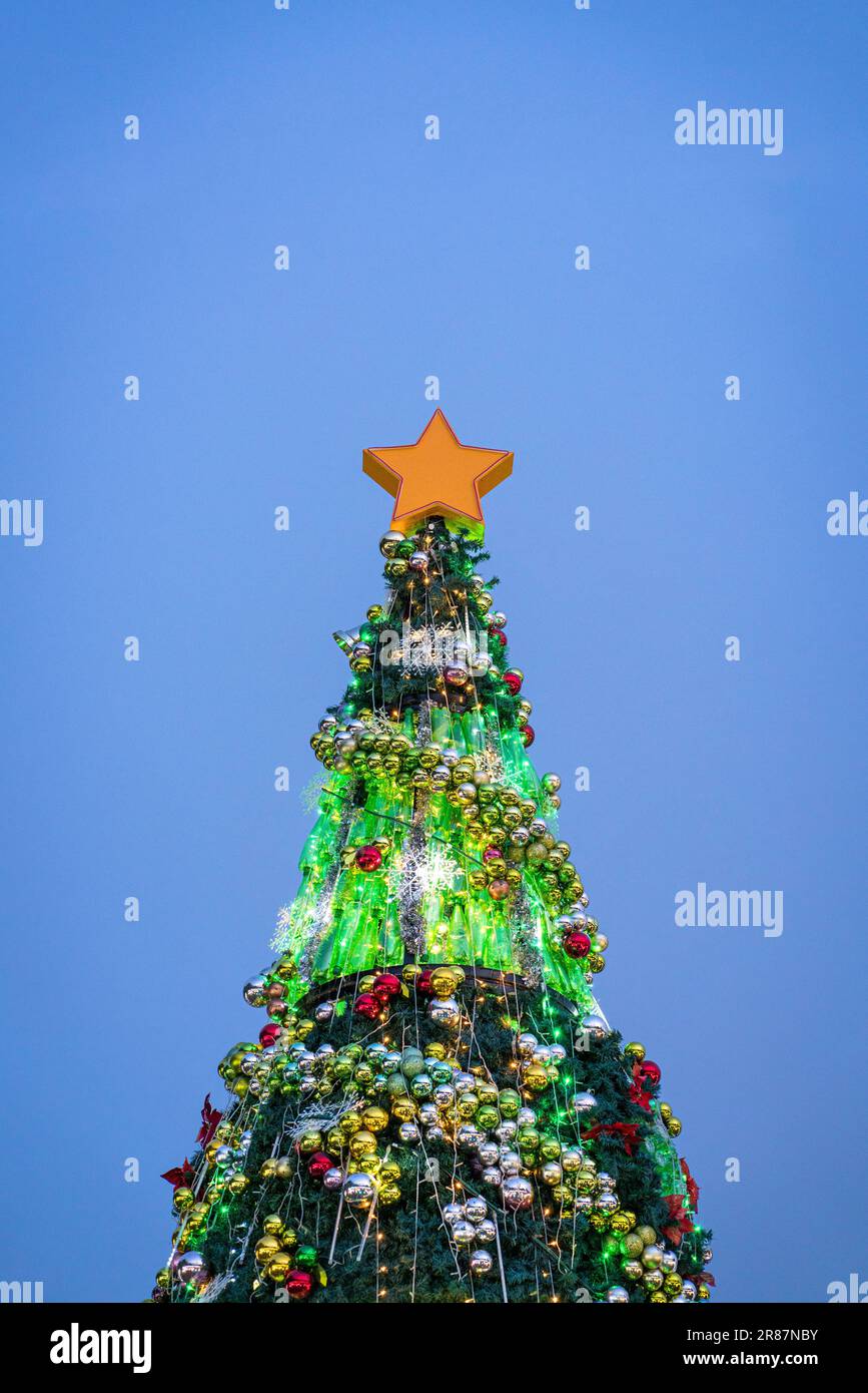 Wunderschön dekorierter Weihnachtsbaum beleuchtet, mit abendlichem blauem Himmelshintergrund. Speicherplatz kopieren. Stockfoto