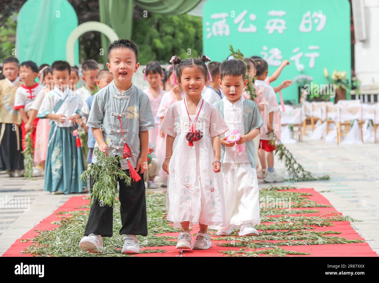 Kindergartenkinder tragen Hanfu und treten auf Wermut, um für Gesundheit in der Stadt Huzhou, Ostchinas Provinz Zhejiang, am 20. Juni 2023 zu beten. Stockfoto