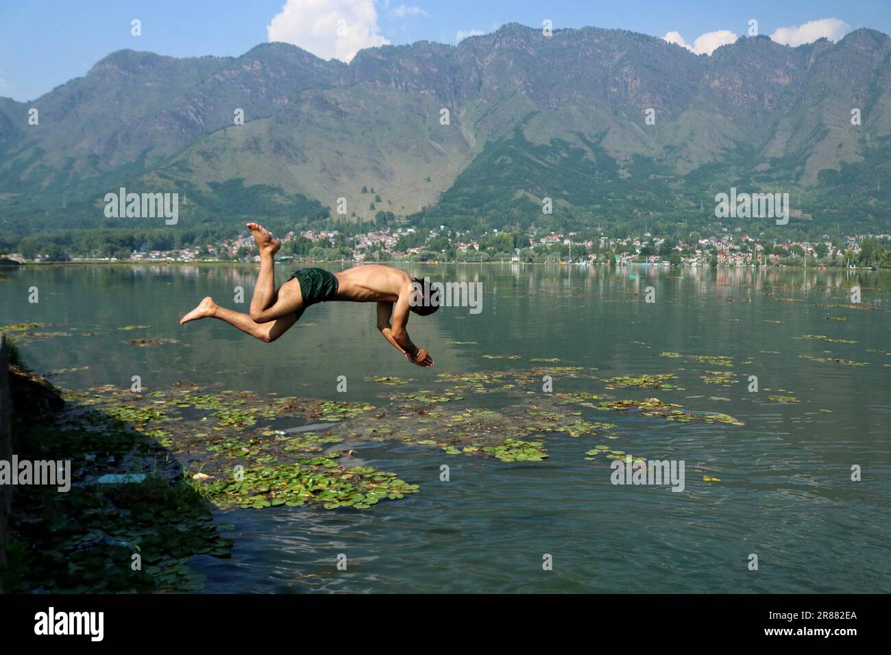 Srinagar Kaschmir, Indien. 19. Juni 2023. Ein Junge springt in die Gewässer des Dal Lake, um sich an einem heißen Tag in Srinagar abzukühlen. Am 19. Juni wurde in Srinagar eine Tagestemperatur von 31 Grad Celsius (87,8 Grad Fahrenheit) festgestellt, da die meteorologische Abteilung in den nächsten Tagen ein heißes und feuchtes Wetter in Kaschmir vorhersagt. (Kreditbild: © Firdous Nazir/Eyepix via ZUMA Press Wire) NUR REDAKTIONELLE VERWENDUNG! Nicht für den kommerziellen GEBRAUCH! Stockfoto