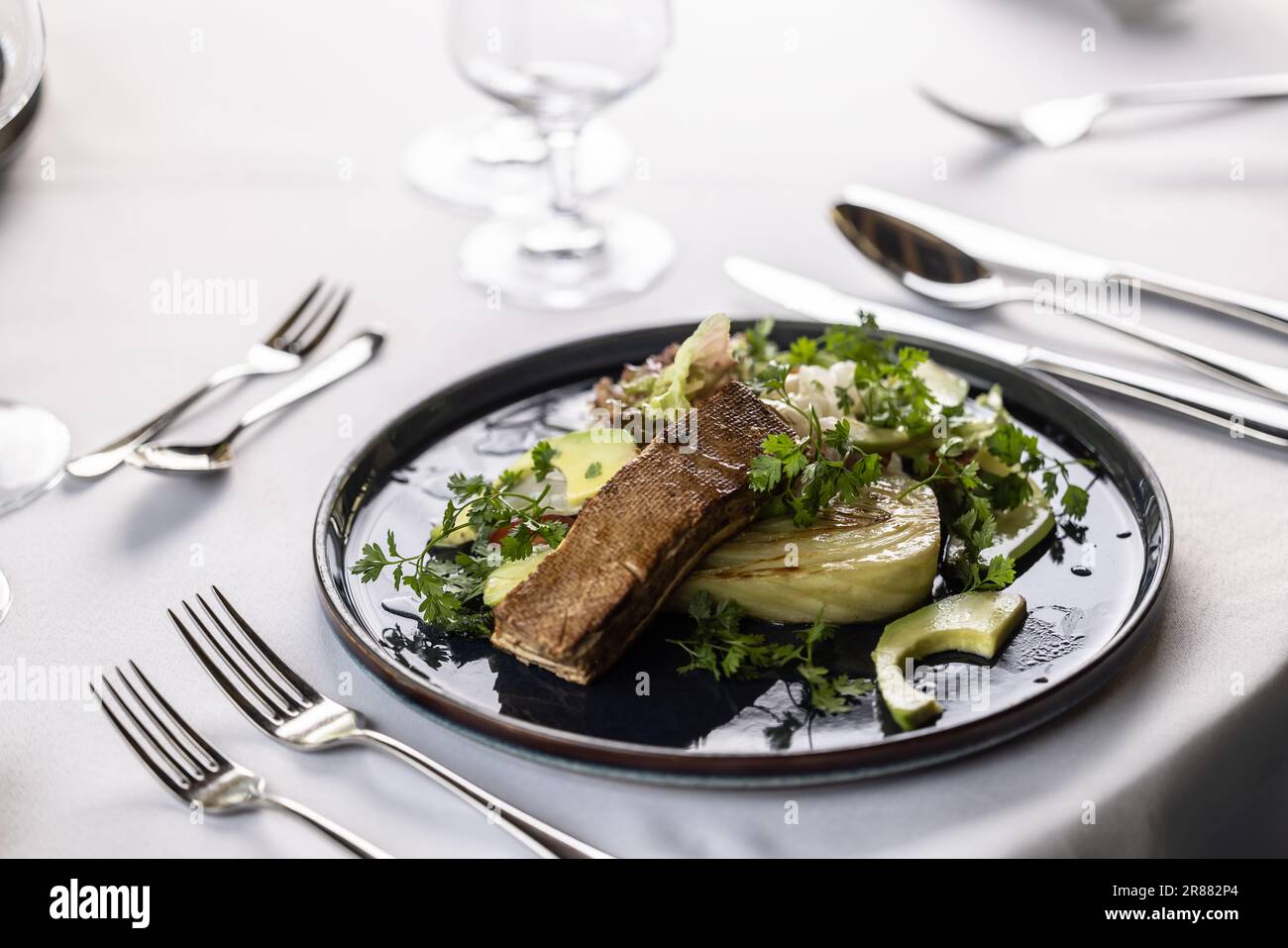 Luxuriöser Tisch mit dunklem Teller voller vegetarischer Salate mit mariniertem Tofu. Stockfoto