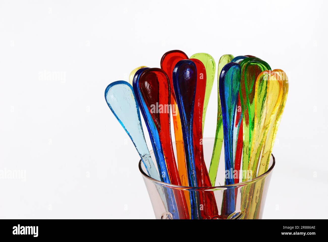Lustige mehrfarbige Partylöffel in einem Glas Stockfoto