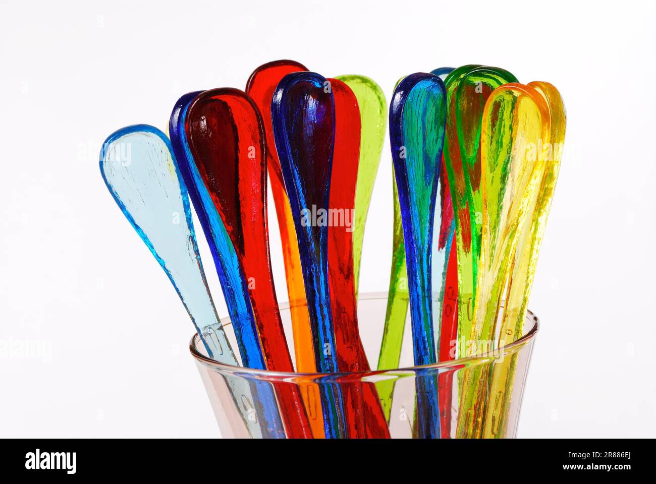 Lustige mehrfarbige Partylöffel in einem Glas Stockfoto