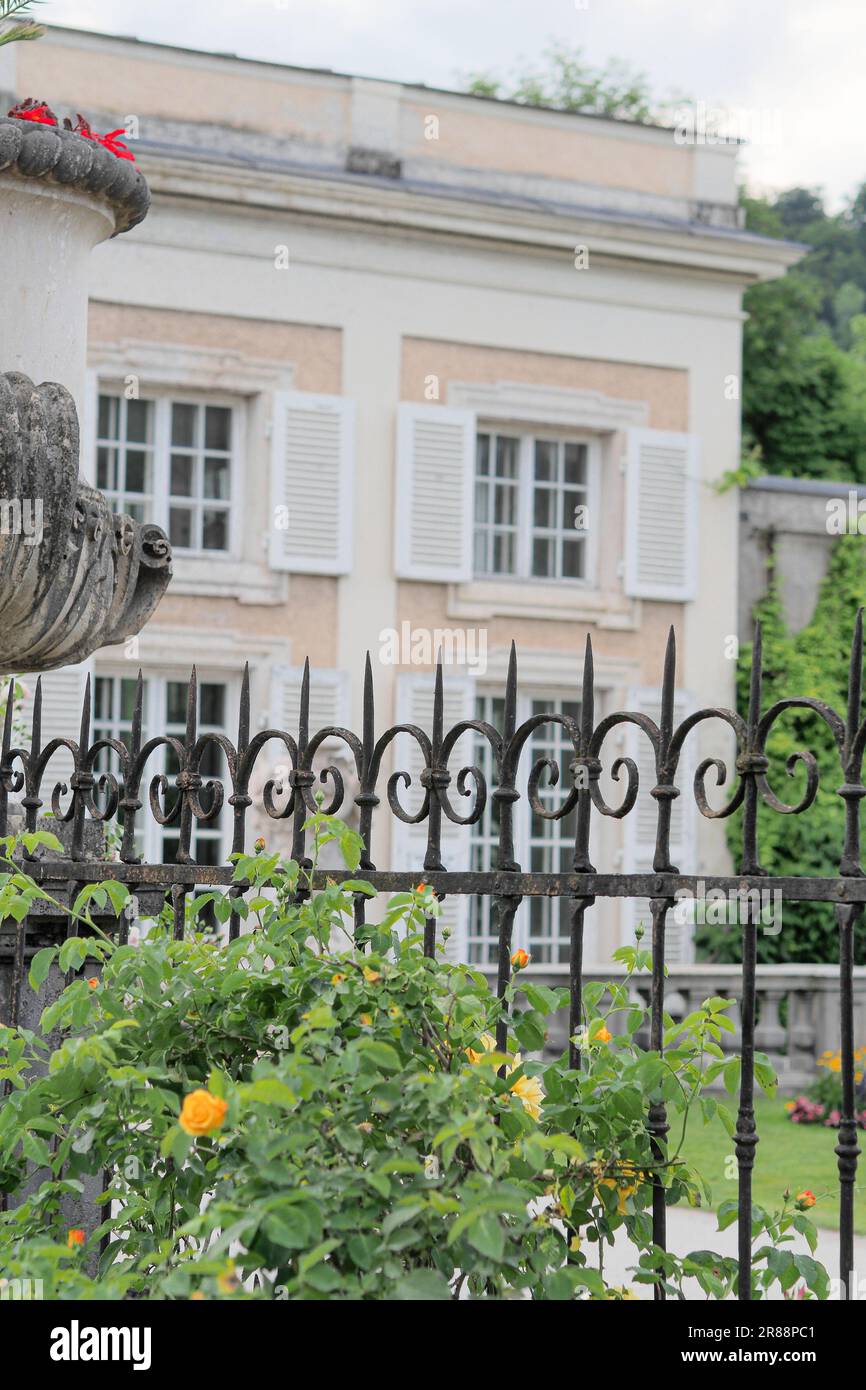 Ein kunstvoll verzierter Eisenzaun vor einem herrschaftlichen Gebäude in Salzburg, Österreich Stockfoto