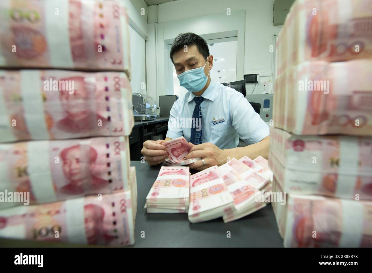 Ein Bankangestellter zählt chinesischen Yuan in Haian, Provinz Jiangsu, China, 20. Juni 2023. Die chinesische Volksbank genehmigte die National Interbank Len Stockfoto