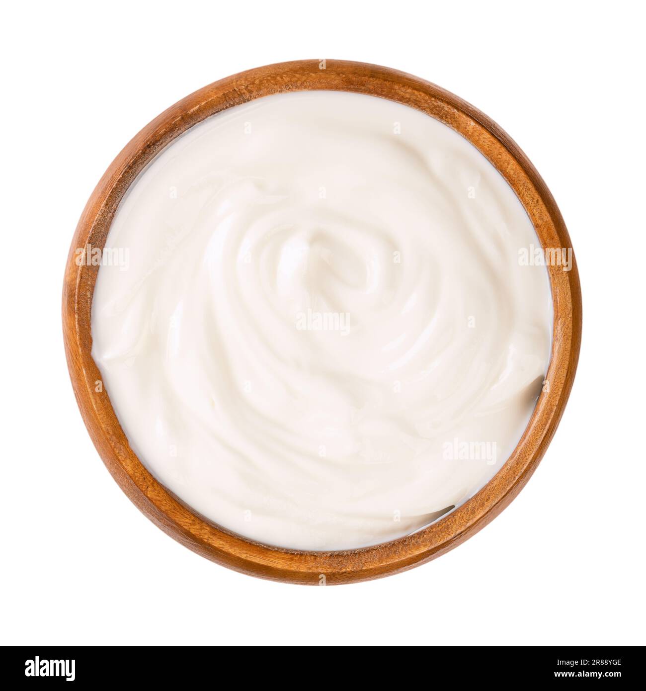 Frischjoghurt, in einer Holzschüssel. Gerührter Joghurt, auch Joghurts oder Joghurts, mit einem Fettgehalt von 10 %. Milchprodukt. Stockfoto