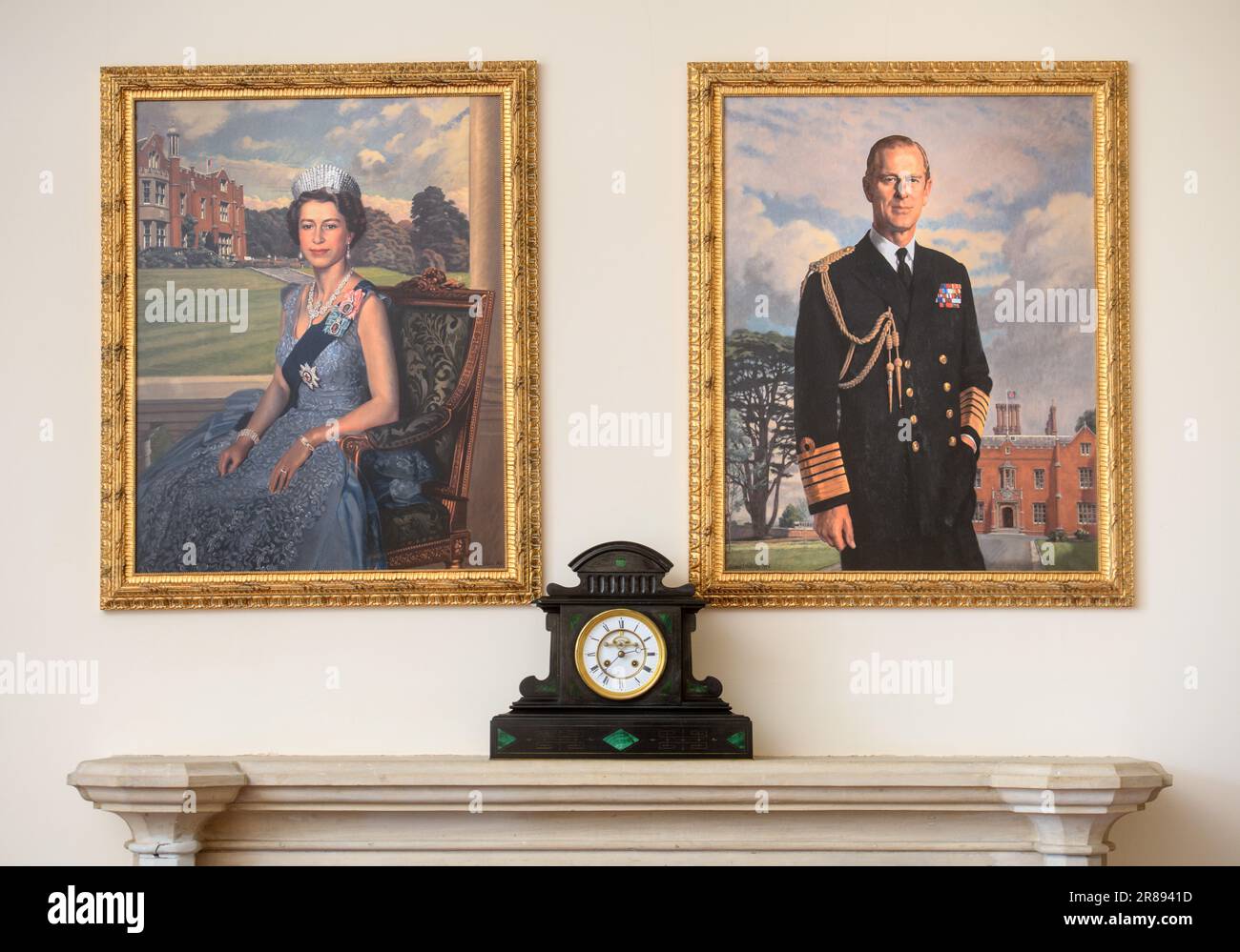 Porträts von Königin Elizabeth II. Und Prinz Phillip, die über einem Kamin in Großbritannien hängen. Stockfoto