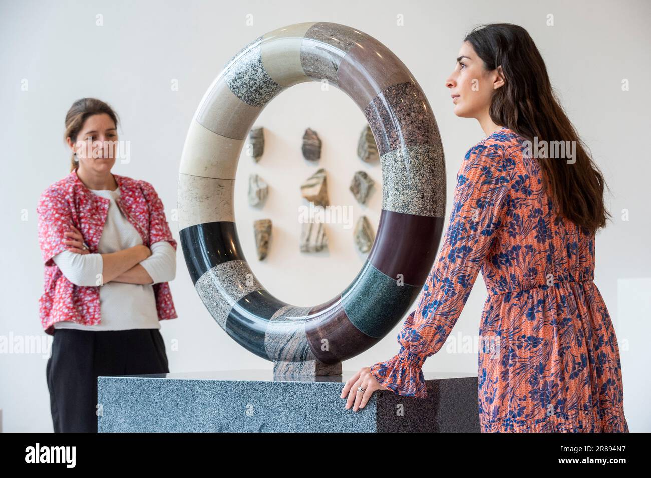 London, Großbritannien. 20. Juni 2023 Mitarbeiter mit „Torus der Zeit“, 2023, 16 Steine, beginnend mit Lewisian Gneiss, etwa 3 Milliarden Jahre alt, Und „Writed in Stone, Journey from the South Pole (xi)“, 2023, beginnend mit Lewisian Gneiss, ca. 3 Milliarden Jahre alt, und White Anorthosite, etwa 2,5 Milliarden Jahre alt (zurück), bei einer Vorschau von „Deep Time: Uncovering Our Hidden Past“, eine neue zeitgenössische Skulpturenausstellung von Angela Palmer in der Pangolin London Sculpture Gallery in der Nähe von King's Cross. Die Arbeiten beleuchten die drei Milliarden Jahre alte Geschichte des Vereinigten Königreichs durch seine Felsen und Steine. Die Show findet am 21. Juni statt Stockfoto