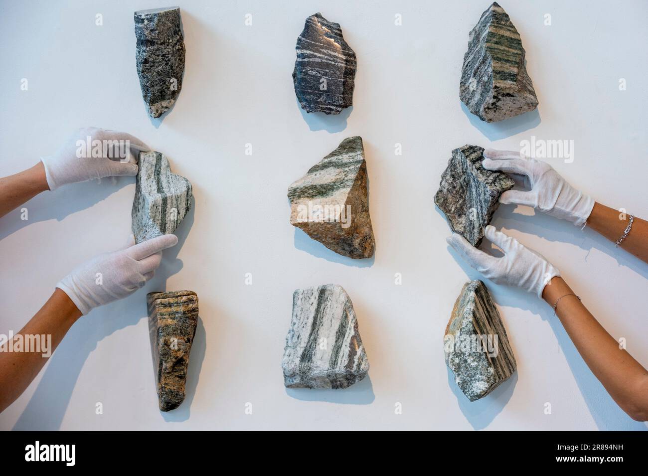 London, Großbritannien. 20. Juni 2023 Mitarbeiter mit „Writed in Stone, Journey from the South Pole (xi)“, 2023, beginnend mit Lewisian Gneiss, ca. 3 Milliarden Jahre alt, und White Anorthosite, ca. 2,5 Milliarden Jahre alt, mit einer Vorschau auf „Deep Time: Uncovering Our Hidden Past“, eine neue zeitgenössische Skulpturenausstellung von Angela Palmer in der Pangolin London Sculpture Gallery in der Nähe von King's Cross. Die Arbeiten beleuchten die drei Milliarden Jahre alte Geschichte des Vereinigten Königreichs durch seine Felsen und Steine. Die Show findet vom 21. Juni bis zum 16. September statt. Kredit: Stephen Chung / Alamy Live News Stockfoto