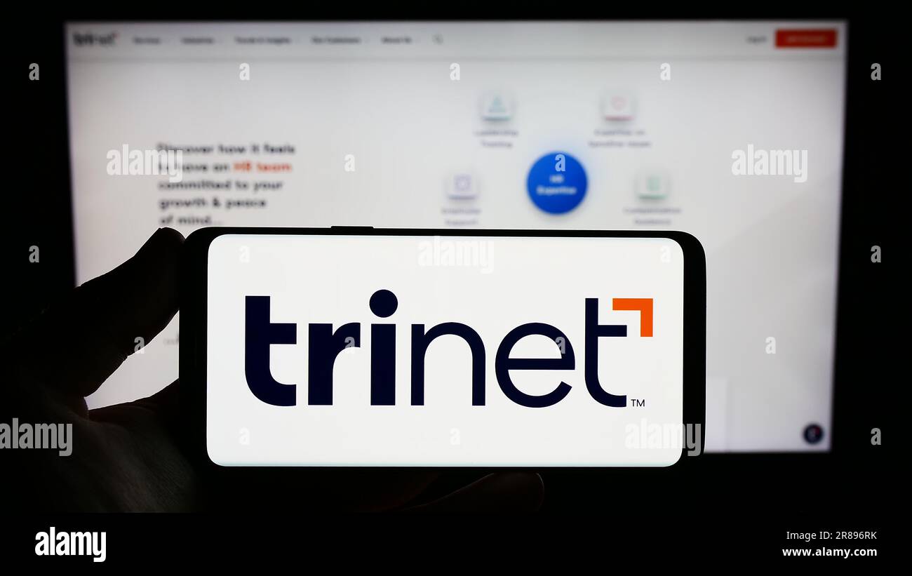 Person, die ein Smartphone mit dem Logo des US-Outsourcing-Unternehmens TriNet Group Inc. Auf dem Bildschirm vor der Website hält. Konzentrieren Sie sich auf das Display des Telefons. Stockfoto Person, die ein Smartphone mit dem Logo des US-Outsourcing-Unternehmens TriNet Group Inc. Auf dem Bildschirm vor der Website hält. Konzentrieren Sie sich auf das Display des Telefons. Stockfoto
