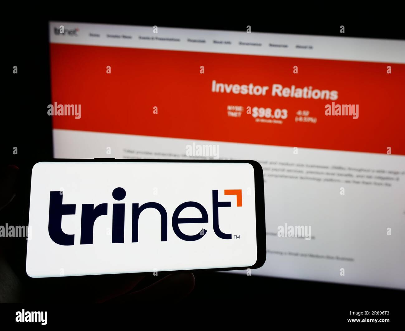 Person, die ein Mobiltelefon mit dem Logo des amerikanischen Outsourcing-Unternehmens TriNet Group Inc. Auf dem Bildschirm vor der Webseite hält. Konzentrieren Sie sich auf das Display des Telefons. Stockfoto Person, die ein Mobiltelefon mit dem Logo des amerikanischen Outsourcing-Unternehmens TriNet Group Inc. Auf dem Bildschirm vor der Webseite hält. Konzentrieren Sie sich auf das Display des Telefons. Stockfoto